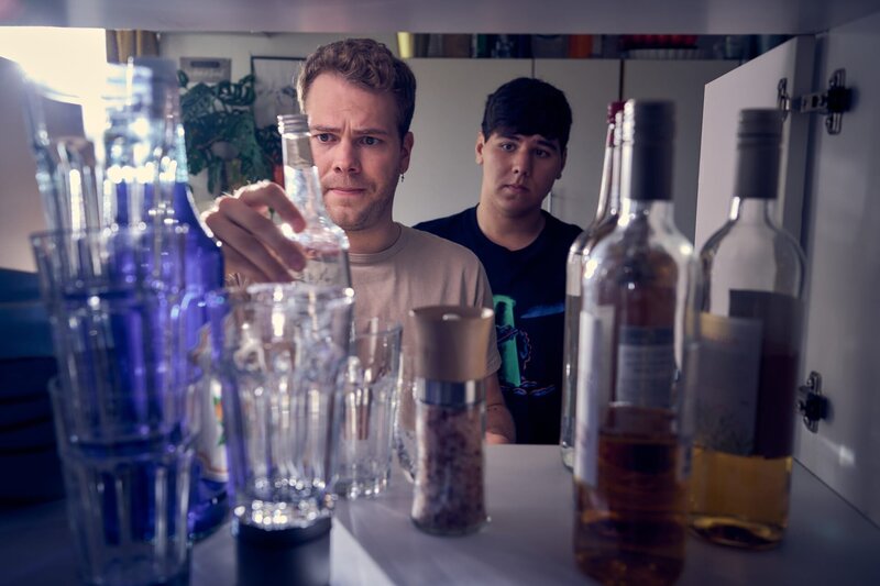 Julian (Ben Münchow, l.) hat eine Mission: Er will Ernst (Diyar Ilhan, r.) dabei helfen, seinen Schwarm mit einer fetten Hausparty zu beeindrucken. Dazu muss erst einmal der Getränkestand gecheckt werden. – Bild: ZDF