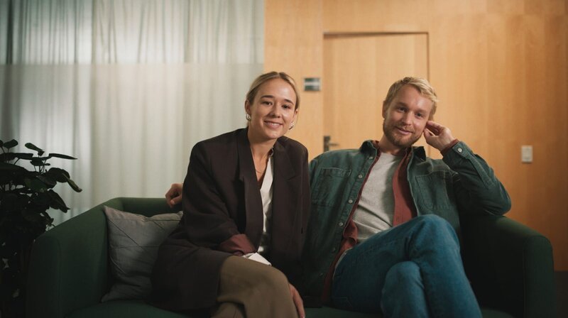 Im Wartebereich der Kinderwunschklinik amüsieren sich Hilma (Alba August) und Ola (Björn Gustafsson) über ein wartendes Kind. – Bild: NDR/​KRO-NCRV