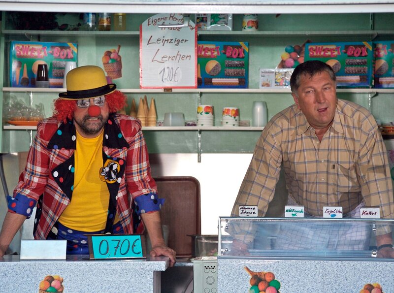 Wieland Hagen (Veit Stübner, re.), Besitzer eines Eiswagens, gewährt seinem langjährigen Freund Harald Meerholm (Matthias Brenner, li.) „Gnadenbrot“ als Eisverkäufer. Doch zu Wielands Leidwesen wird Harald im Eiswagen regelrecht zum Werbegenie, das auf Zuverlässigkeit nicht den geringsten Wert legt. – Bild: NDR/​MDR/​Krajewsky