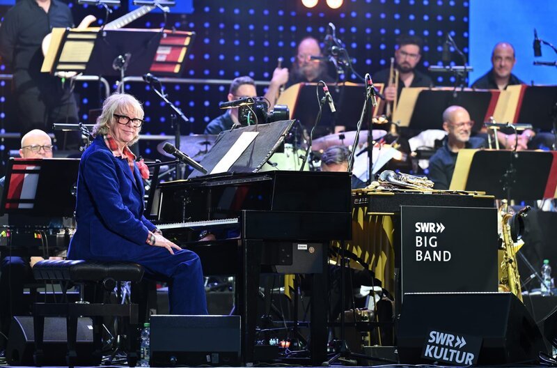 Helge Schneider (am Klavier) beim SWR Sommerfestival in Speyer: Er gehört zu den erfolgreichsten Komikern und Musikern in Deutschland – Hits wie „Katzenklo“ und „Käsebrot“ sind längst musikalisches Kulturgut. Beim SWR Sommerfestival tritt er erstmals mit einer großen Big Band auf – mit der mehrfach Grammy-nominierten SWR Big Band. – Bild: SWR/​Jörg Puchmüller