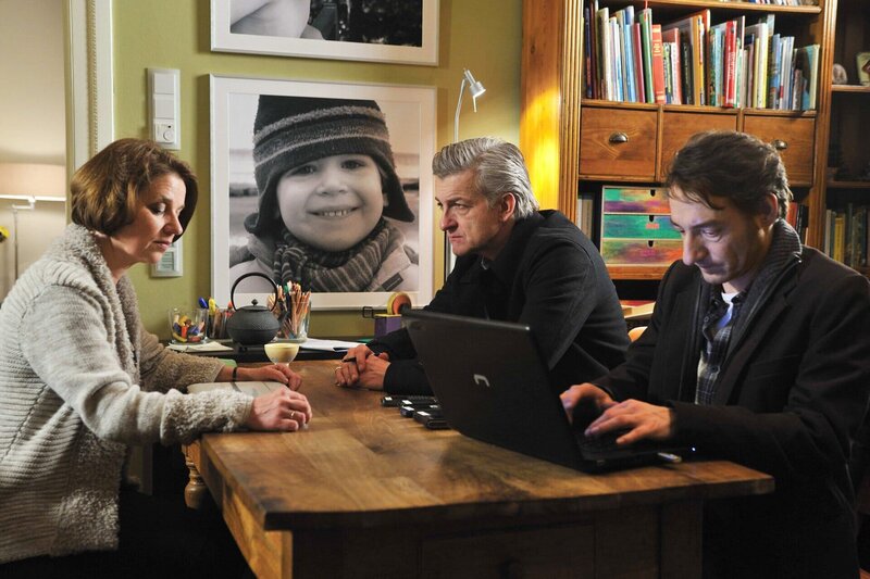 Die beiden Kommissare (Dominic Raacke, Mitte, Boris Aljinovic) rekonstruieren mit Linda Steiner (Lena Stolze) den Tagesablauf der Familie. Im Hintergrund ein Bild des entführten Benjamin (Mika Seidel). – Bild: ARD Degeto/​rbb/​Hardy Spitz