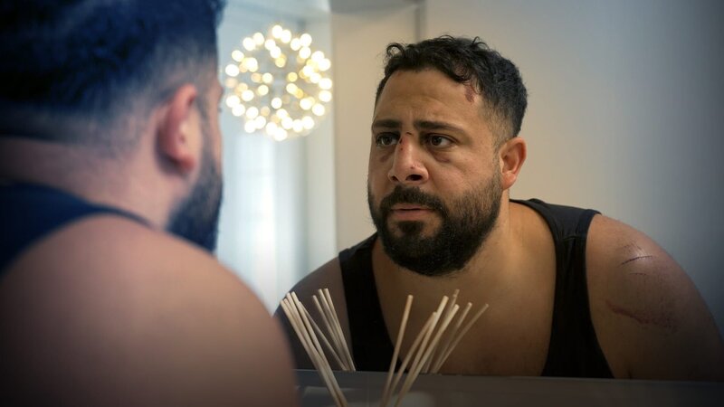 Serkan Kaya sieht sein lädiertes Gesicht im Spiegel. – Bild: ZDF