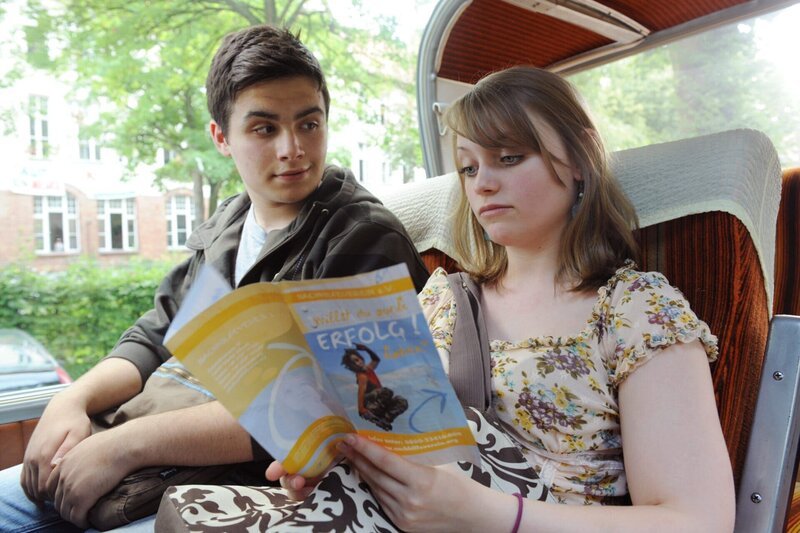 Timo (Aram Arami, l.) zeigt Svenja (Geraldine Raths, r.) das Prospekt des Nachhilfevereins, bei dem er teuren Nachhilfe-Unterricht nimmt. – Bild: SWR/​ARD/​Claudius Pflug