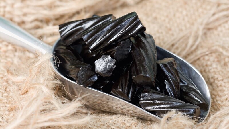 A scoop of old fashioned black liquorice candy on frayed burlap. – Bild: skhoward /​ Getty Images /​ E+ GettyImages-157770873.jpg /​ skhoward