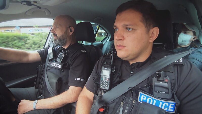 Polizeibeamte, die in einem Auto sitzen. – Bild: Warner Bros. Discovery