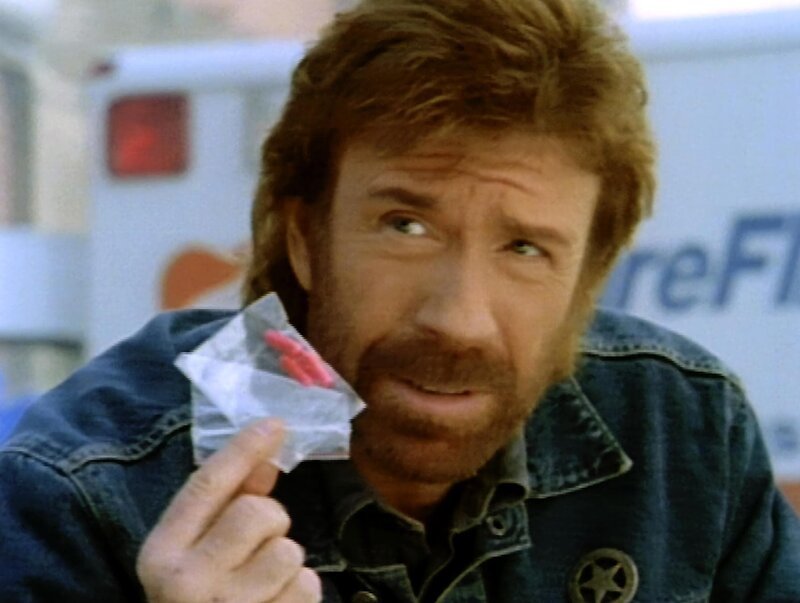 Walker (Chuck Norris) untersucht die Leiche des getöteten Russen und stößt dabei auf ein kleines Päckchen mit roten Tabletten, das er zur Untersuchung in die Gerichtsmedizin schickt. – Bild: RTL II