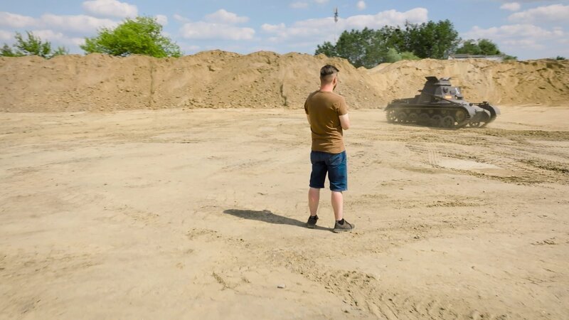 Kryzstof Jankowiak neben einer Nachbildung eines Panzers – Bild: National Geographic for Disney /​ Disney