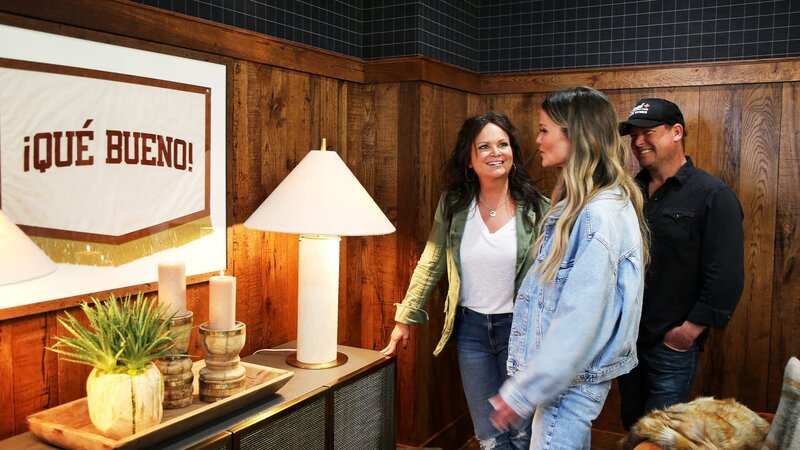 Cristi & Ben Dozier are thrilled that Amy Brown is touched by the custom „Que Bueno“ banner that the couple had made to honor Cristi & Amy’s late father. – Bild: Warner Bros. Discovery