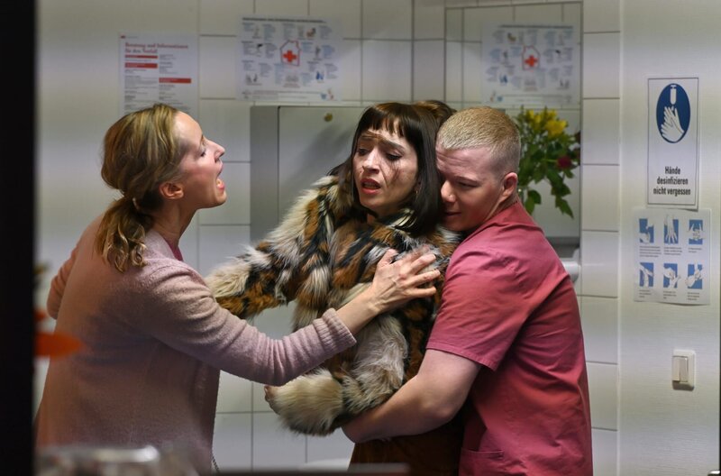 Beim Versuch, eigenmächtig an ihre Patientenakte zu gelangen, stößt Chloé Mura (Olivia Gräser, l.) auf Widerstand der Krankenschwester Sandra Berlitz (Silvina Buchbauer, l.) und deren Kollegen (Komparse, r.). – Bild: ARD/​Hardy Spitz