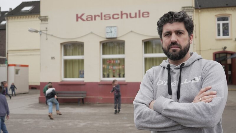 Sportlehrer Jan Buchholz hat viele Schüler, auch aus Flüchtlingsfamilien, aber keine Sporthalle in der er unterrichten kann. – Bild: i&uTV /​ ZDF und i&uTV