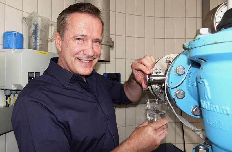 Alexander Herrmann zapft an der Quelle ein Glas Wasser bei der Siegsdorfer Petrusquelle (Lkr. Traunstein, Oberbayern). – Bild: BR/​Jürgen Endriß