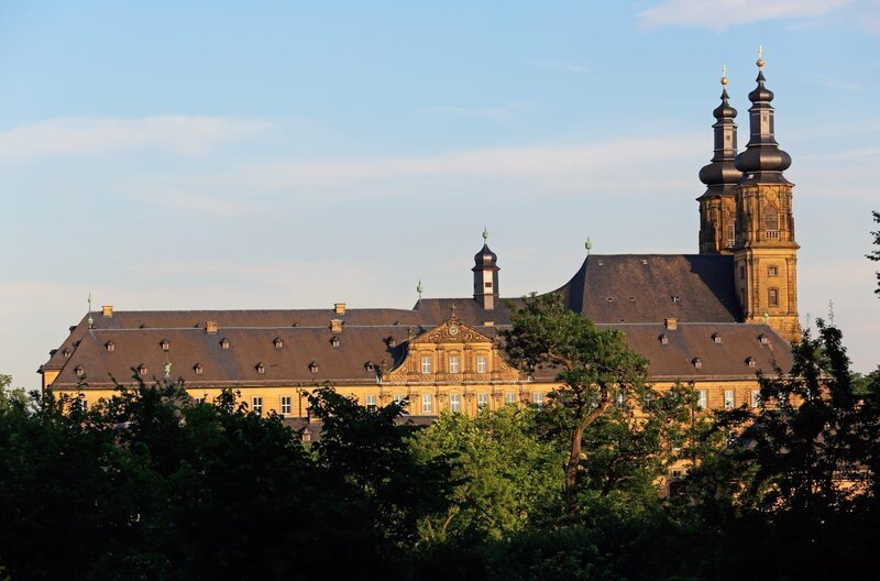 Die malerische Kulisse von Kloster Banz bei Bad Staffelstein, stimmgewaltige Sängerinnen und Sänger auf der Bühne und tausende begeisterte Fans beim Picknick auf der Klosterwiese – all das steht für „Lieder auf Banz“. Das BR Fernsehen zeigt eine zweistündige Zusammenfassung des größten Festivals deutschsprachiger Liedermacher. Bild: Kloster Banz in Bad Staffelstein. – Bild: BR/​Thomas Rex