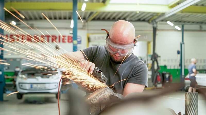 Ein Mechaniker schweißt ein Teil eines Autos. – Bild: DMAX