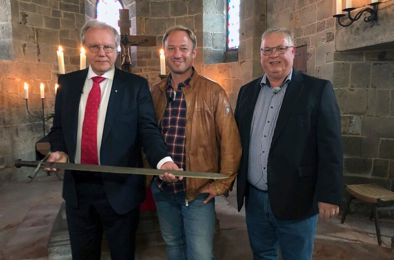 Tobi Kämmerer (Mitte) in der Komturkirche des Johanniterordens im Butzbacher Stadtteil Nieder-Weisel mit Ritter Johannes Meyer Bretschneider (links) und Markus Franke. – Bild: HR/​Friso Richter