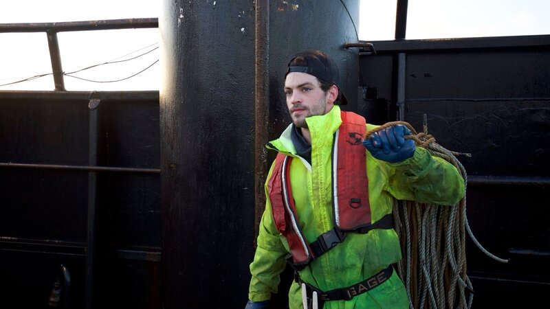 Deckhand Tyler Gateman, of the F/​V Wizard, hauls some rope for the pots. – Bild: Discovery Communications