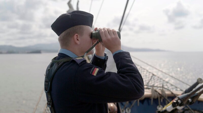HESSISCHER RUNDFUNK Y-KOLLEKTIV: DRILL AUF HOHER SEE – ALS MARINESOLDAT AUF DER GORCH FOCK, Ein Film von Lukas Wiehler, ab Montag (04.08.25) in der ARD Mediathek. Die „Gorch Fock“ verlässt den Hafen von Ponta Delgada auf den Azoren: Das letzte Mal Land für die nächsten zwei Wochen. – Bild: HR/​Julian Kiesche