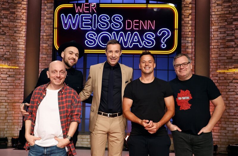 Moderator Kai Pflaume (M.) und seine Rateteam-Kapitäne Bernhard Hoëcker (l.) und Elton (r.) begrüßen in dieser Sendung den Sänger Max Mutzke (2.v.l.) und den Sänger Alexander Knappe (2.v.r.). – Bild: ARD/​Morris Mac Matzen