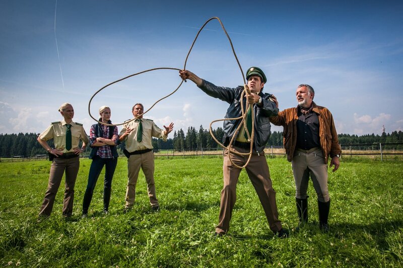 Staller (Helmfried von Lüttichau, 2.v.r.) will das entlaufene Pferd auf der Wiese von Bauer Pauli mit einem Lasso einfangen. Hubert (Christian Tramitz, 3.vl.), Sonja (Annett Fleischer, l.) und Kati (Julia Nalbach, 2.v.l.) schauen verständnislos zu. Hermann Meixner (Michele Oliveri, r.) bietet seine Hilfe an. – Bild: Leonine /​ Chris Hirschhäuser