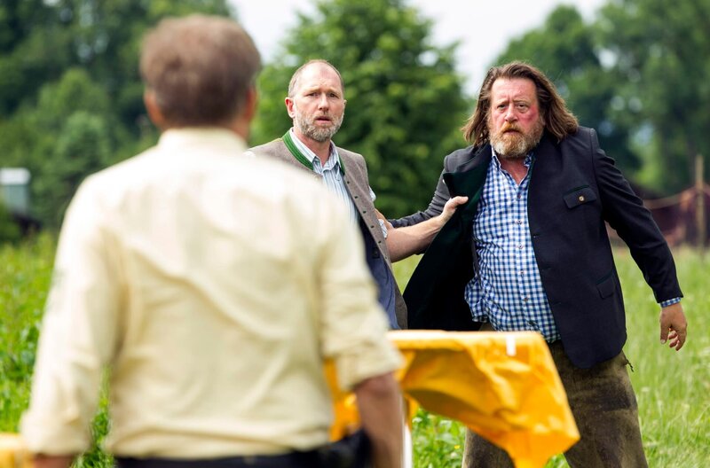 Ferdinand Mayer (Andreas Schwaiger, Mitte) und Josef Schmidl (Johannes Glocke, rechts) kriegen sich über Bio-Würstl in die Wolle. – Bild: ARD/​TMG/​Chris Hirschhäuser