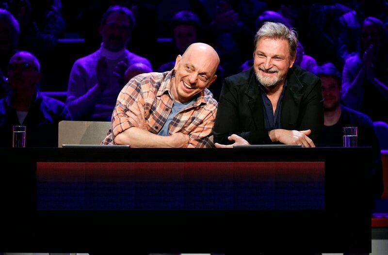 Rateteam-Kapitäne Bernhard Hoëcker (l.) mit Schauspieler Stefan Jürgens (r.). – Bild: ARD/​Morris Mac Matzen
