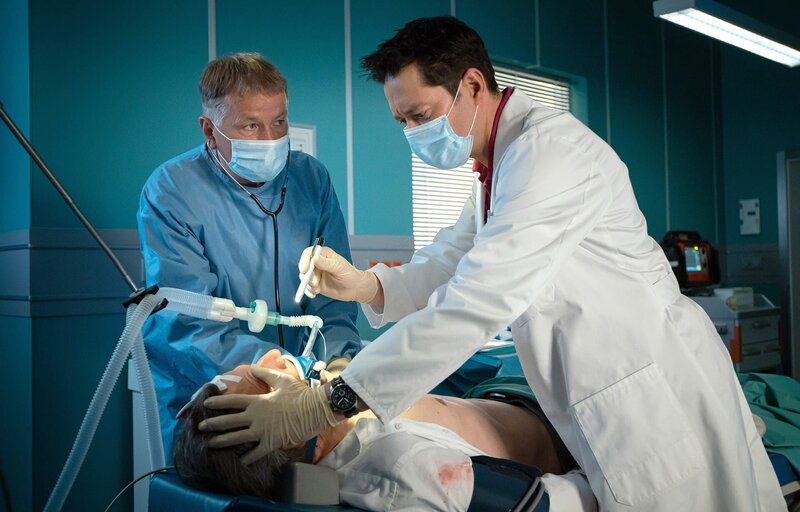 Stefan Brückner (René Steinke, liegend) wird nach einem schweren Verkehrsunfall in die Sachsenklinik eingeliefert. Gemeinsam mit Dr. Philipp Brentano (Thomas Koch, rechts) übernimmt Dr. Roland Heilmann (Thomas Rühmann, links) den Patienten. – Bild: BR/​MDR/​Saxonia Media/​Rudolf Wernicke