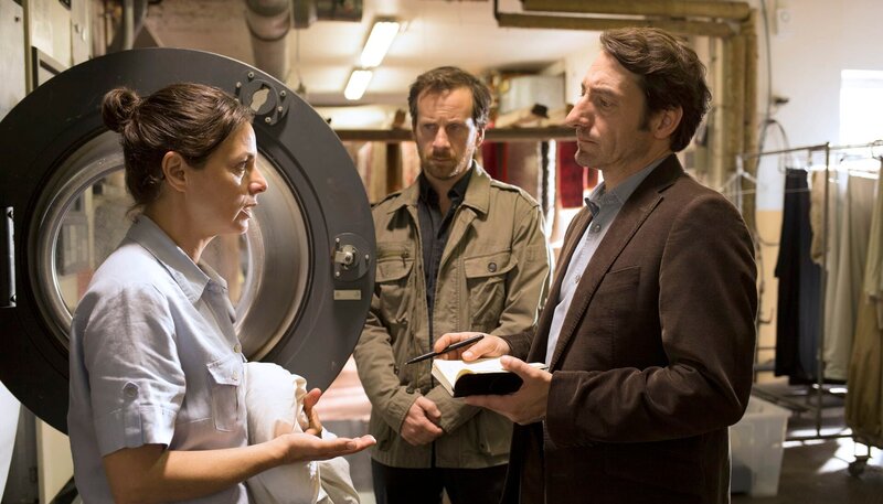 Der Psychologe Robert Meinhardt (Fabian Busch, Miitte) und Stark (Boris Aljinovic) übermitteln Frau Steiger (Naomi Krauss) den Tod ihrer Tochter. – Bild: rbb/​Frédéric Batier