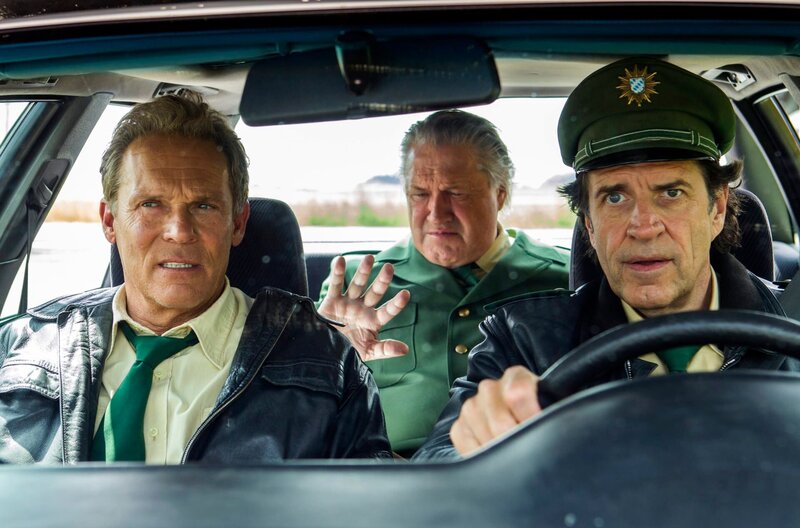 Hubert (Christian Tramitz, l.) und Staller (Helmfried von Lüttichau, r.) fahren mit Girwidz (Michael Brandner, M.) im Streifenwagen. – Bild: ARD/​TMG/​Chris Hirschhäuser