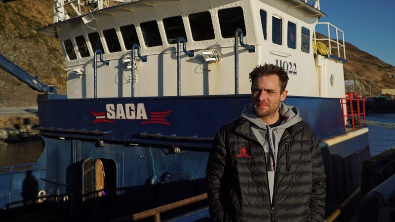 Captain Jake Anderson stands in front of his boat, the Saga. – Bild: Discovery Channel /​ Discovery Communications