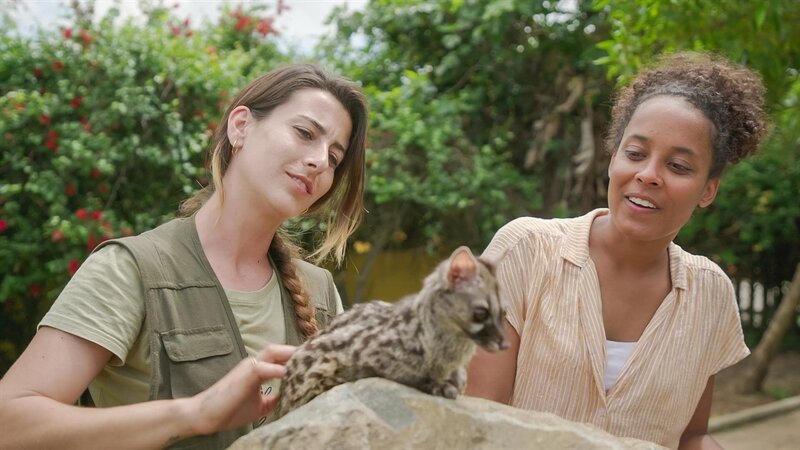 Pia (rechts) und Tierpflegerin Tanja mit der Kleinfleck-Ginsterkatze Chica. Tanja hat das kleine Raubtier mit der Flasche aufgezogen. – Bild: BR/​TEXT+BILD Medienproduktion GmbH & Co. KG/​Matthias Kraus