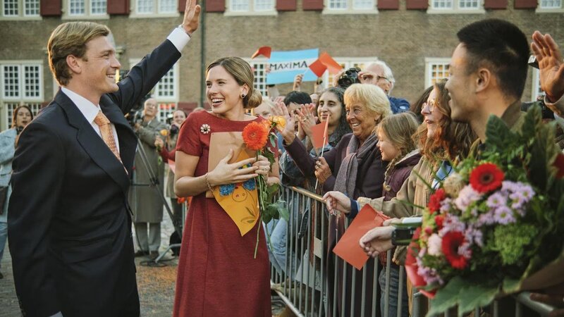 Nach der Pressekonferenz werden Willem-Alexander (Martijn Lakemeier) und Maxima (Delfina Chaves) von einer jubelnden Menge empfangen. – Bild: TVP