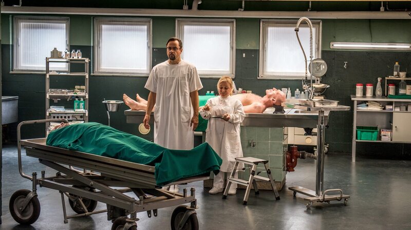 In der Rechtsmedizin müssen Prof. Karl-Friedrich Boerne (Jan Josef Liefers, links) und Silke Haller (ChrisTine Urspruch, rechts) einen weiteren Toten unter die Lupe nehmen. – Bild: WDR/​Wolfgang Ennenbach