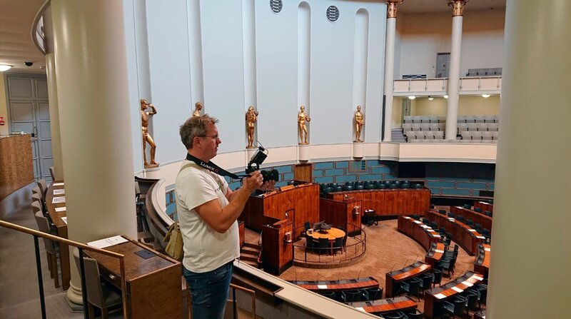 Nur 5,3% der Finnen sprechen Schwedisch. Trotzdem gilt diese Sprache nicht als Minderheitensprache, denn Finnland hat sich entschlossen ein zweisprachiges Land zu sein. Wir wollen wissen, wie diese Zweisprachigkeit funktioniert und wie eine so kleine Anzahl von Finnlandschweden das Land trotzdem prägen können. – Parlamentssaal in Finnland – Bild: rbb/​Britt Wulff