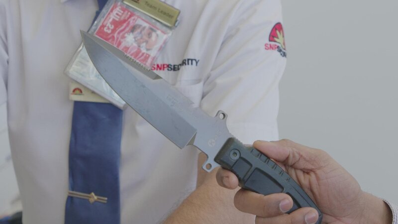 Nathan von der Sicherheitskontrolle hält einen Passagier fest, der ein Jagdmesser bei sich trägt. Die australische Bundespolizei muss entscheiden, ob sie den Mann anklagen will. – Bild: ITV Studios Australia