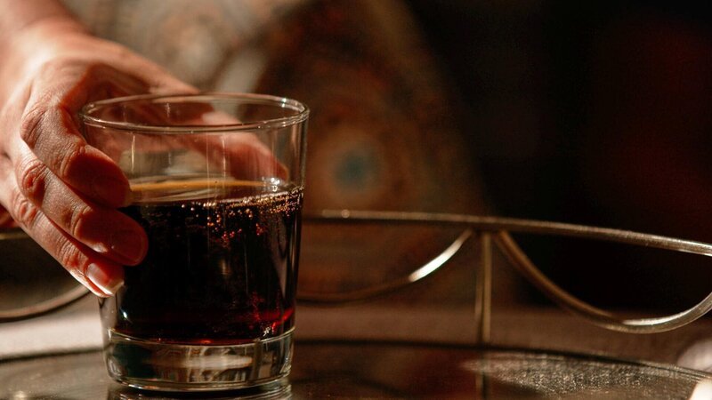 Eine Hand hält ein Glas auf dem Tisch – Bild: Crime + Investigation /​ fairpoint