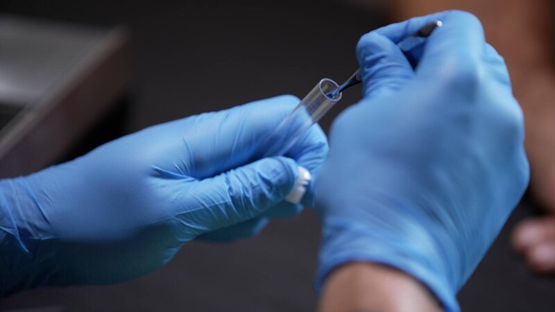 Hände, Reagenzglas und Pinzette – Bild: Crime + Investigation /​ fairpoint