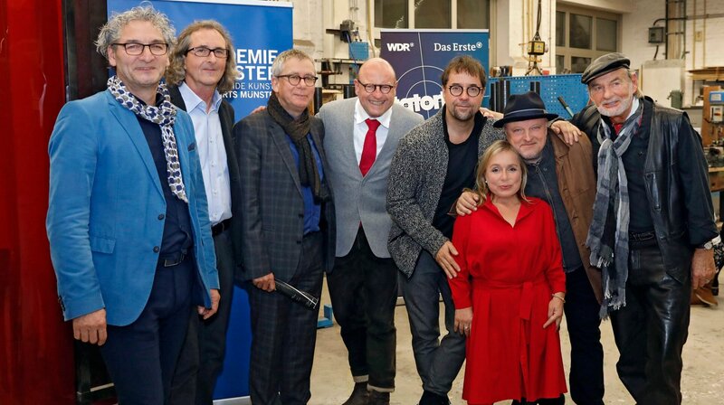 Zur Premierenfeier des Münsteraner Tatorts haben sich die Veranstalter einen besonderen Ort ausgesucht, der gleichzeitig Schauplatz in der neuen Folge „Gott ist auch nur ein Mensch“ ist: Die Kunstakademie am Leonardo-Campus. Hier beim Gruppenfoto in der Werkstatt der Akademie v.l. Kunstakademie-Kanzler Frank Bartsch, Rektor Mike Labbert, WDR-Fernsehfilmchef Prof. Gebhard Henke, Münster-OB Markus Lewe, die Schauspieler Jan Josef Liefers, ChrisTine Urspruch, Axel Prahl und Claus D. Clausnitzer. – Bild: WDR/​Klaus Görgen