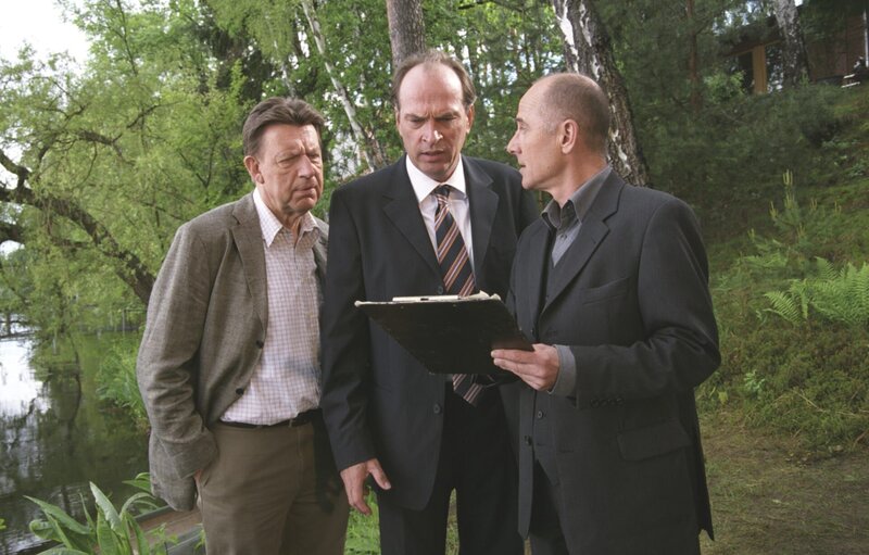 Staatssekretär Alex Leidhoff (Herbert Knaup, M.) gerät in Erklärungsnot, als er von Dr. Robert Kolmaar (Ulrich Mühe, r.) mit den Indizien konfrontiert wird. Daneben steht Joe Hoffer (Jörg Gudzuhn, l.). – Bild: ZDF