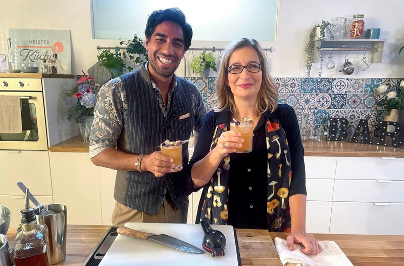 Die passenden Drinks zum leckeren Essen hat Bartender Nic Shanker (l) am Start. Gemeinsam mit Yvonne Willicks (r) mixt er einen selbst kreierten Aperitif mit italienischen Zutaten, den er Amarino nennt. – Bild: WDR