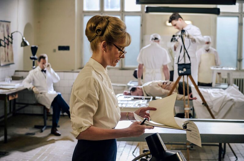 ARD CHARITÉ III. Staffel mit (6 neuen Folgen), Folge 2 „Blutsauger“ am Dienstag um 21:05 Uhr im Ersten. Im Obduktionssaal: Laborgehilfe Wittenberg (Thimo Meitner, r.) fotografiert die Leiche, Frau Dammrau (Cristin König, im VG) liest Protokoll, Im HG Prof. Dr. Otto Prokop (Philipp Hochmair). – Bild: ARD/​Stanislav Honzik