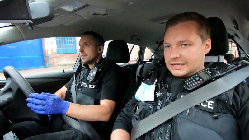 Police officers in car. – Bild: Warner Bros. Discovery