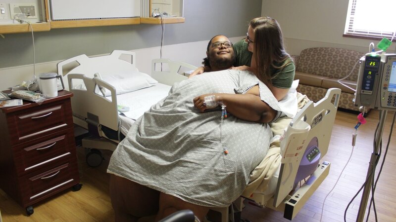 Brandon is in a hospital bed with his girlfriend behind him. – Bild: Discovery Communications.