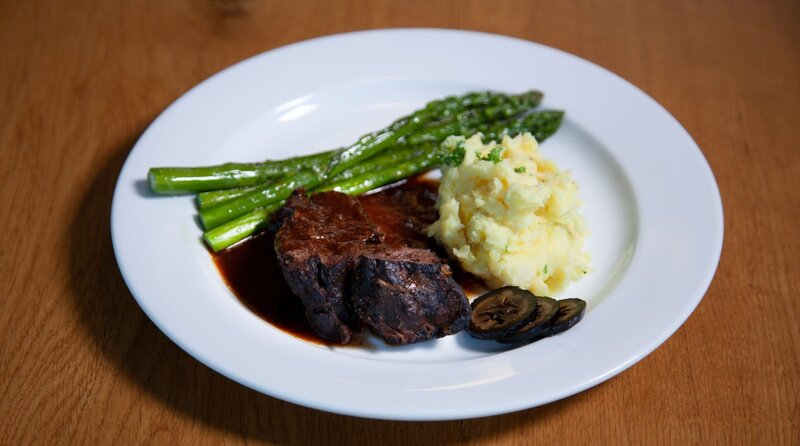 Hauptspeise: Geschmorte Rinderbäckchen mit Kartoffelstampf, grünem Spargel und schwarzen Nüssen – Bild: SWR/​Anne Deiss