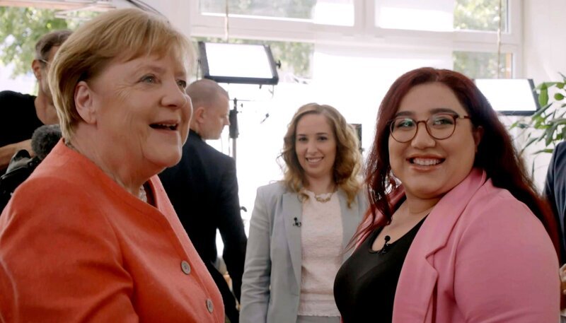Angela Merkel (li.) trifft sich mit Geflüchteten – zehn Jahre nachdem sie gesagt hat: „Wir schaffen das“. Unter anderem mit Mahsa Narimani (27) (re.), sie floh damals aus dem Iran. – Bild: WDR Angela Merkel (li.) trifft sich mit Geflüchteten – zehn Jahre nachdem sie gesagt hat: „Wir schaffen das“. Unter anderem mit Mahsa Narimani (27) (re.), sie floh damals aus dem Iran. – Bild: WDR
