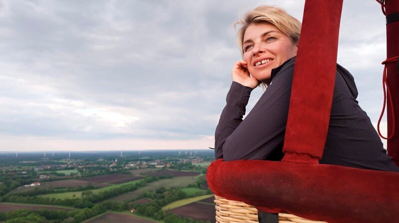 „Verzaubert am Rand vom Land – Sabine Heinrich umrundet auf einer 1.600 Kilometer langen Reise NRW. Im Heißluft-Ballon geht sie dabei kurz über die Grenze und landet im niedersächsischen Emsland.“ – Bild: WDR/​klarlogo