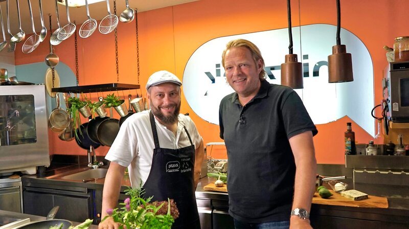 Ein „Hoi“ oder auch ein herzliches Hallo – es grüßen die Südtiroler Alpen! Für Spitzenkoch Björn Freitag geht es in eine der ältesten Städte der Region Tirol: Brixen oder Bressanone – wie man auf Italienisch sagt. Wie immer ist er auf der Suche nach dem besonderen kulinarischen Erlebnis und ausgefallenen Genusserzeugern. – Björn Freitag mit Koch Oskar Messner (l) vom Restaurant „Pitzock“. – Bild: WDR/​2Bild GmbH/​Sophie M. Neuer