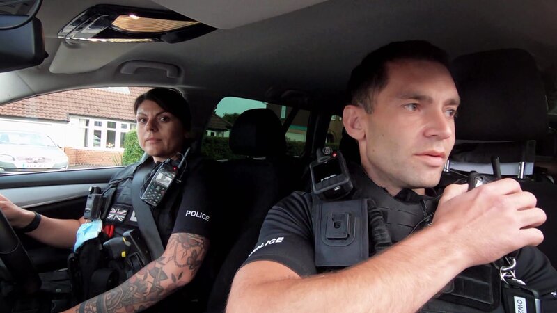 Polizeibeamte in einem Auto. Lisa Desantis (l.) und Paul Charlesworth (r.) – Bild: Warner Bros. Discovery