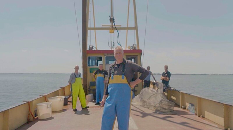 Die letzten Fischer von Volendam – Patrick Schilder auf seinem Boot, auf dem Jisselmeer. Im Hintergrund: Seine Crew. – Bild: WDR/​Fritz Sprengrat