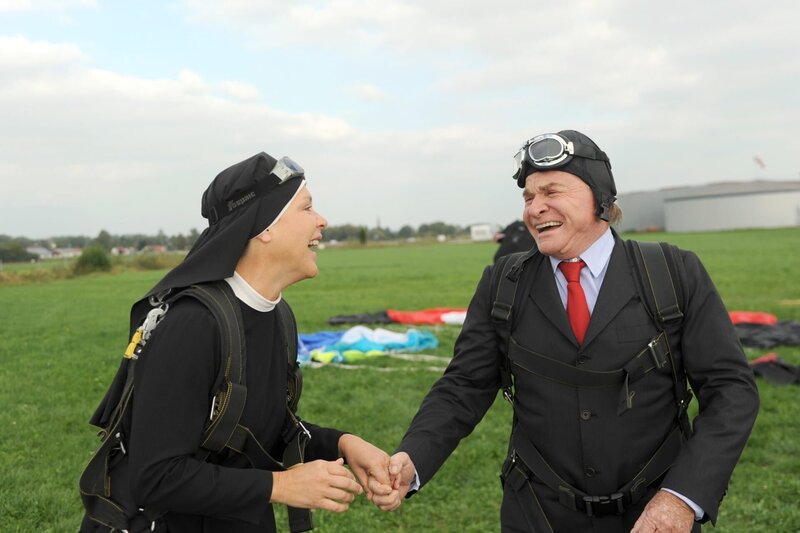 Wöller (Fritz Wepper) erfüllt Schwester Hanna (Janina Hartwig) einen möglicherweise letzten Wunsch: Fallschirmspringen. – Bild: ORF/​Kineos/​Barbara Bauriedl