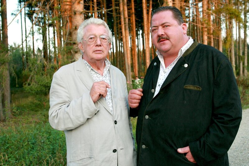 Harry Norden (Dieter Thomas Heck, li.) muss sich von Korbinian Hofer (Joseph Hannesschläger) einige Fragen gefallen lassen, denn der Ernmordete war Nordens Geschäftspartner. – Bild: ORF/​ZDF/​Christian A. Rieger