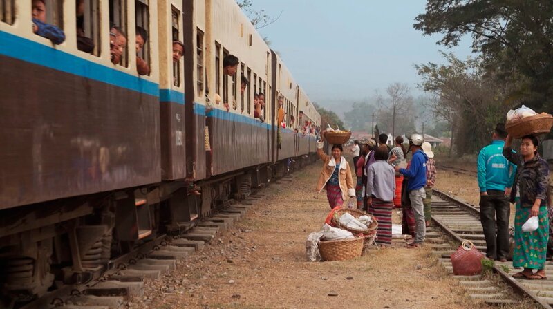 Fliegende Händler versorgen die Zugreisenden der Myanmar Railsways mit allerlei Köstlichkeiten. – Bild: NDR